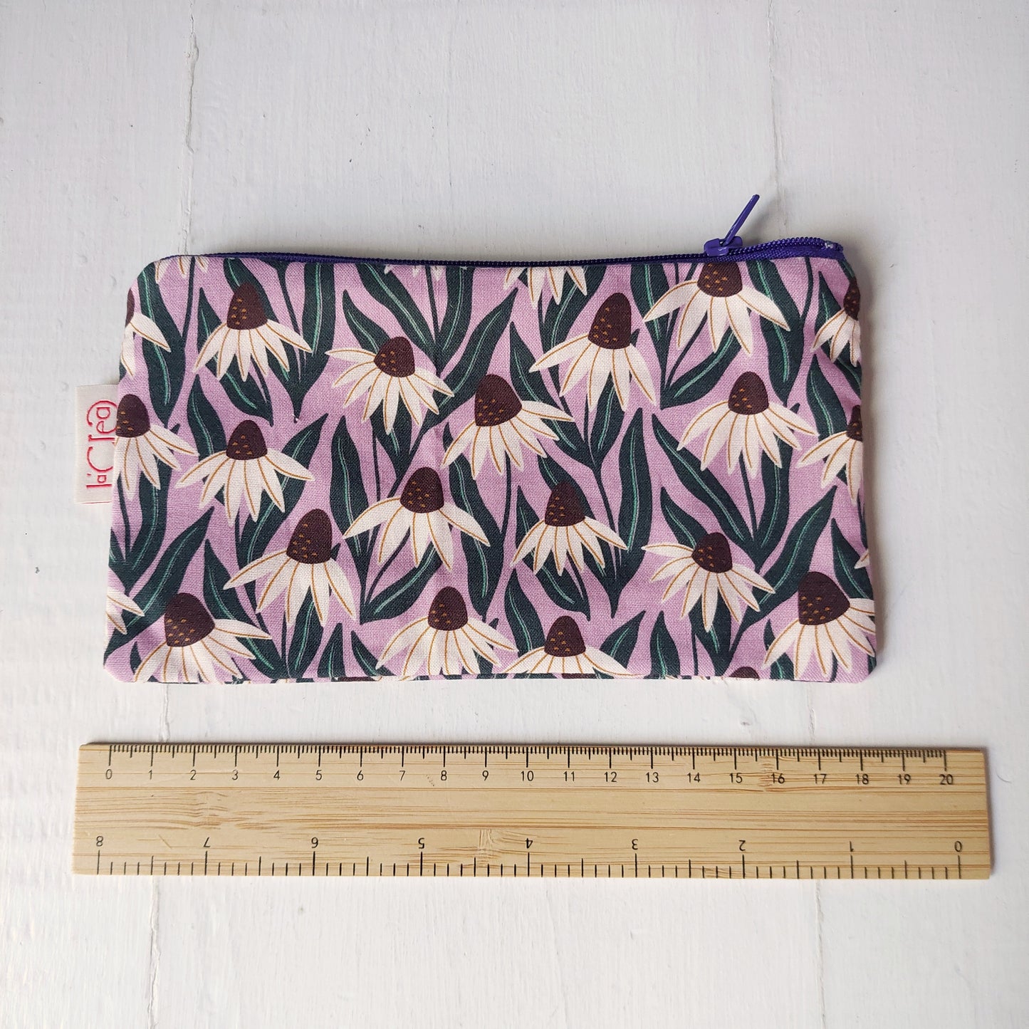 Pochette in cotone viola, bianco e verde con decorazione floreale, foderata.