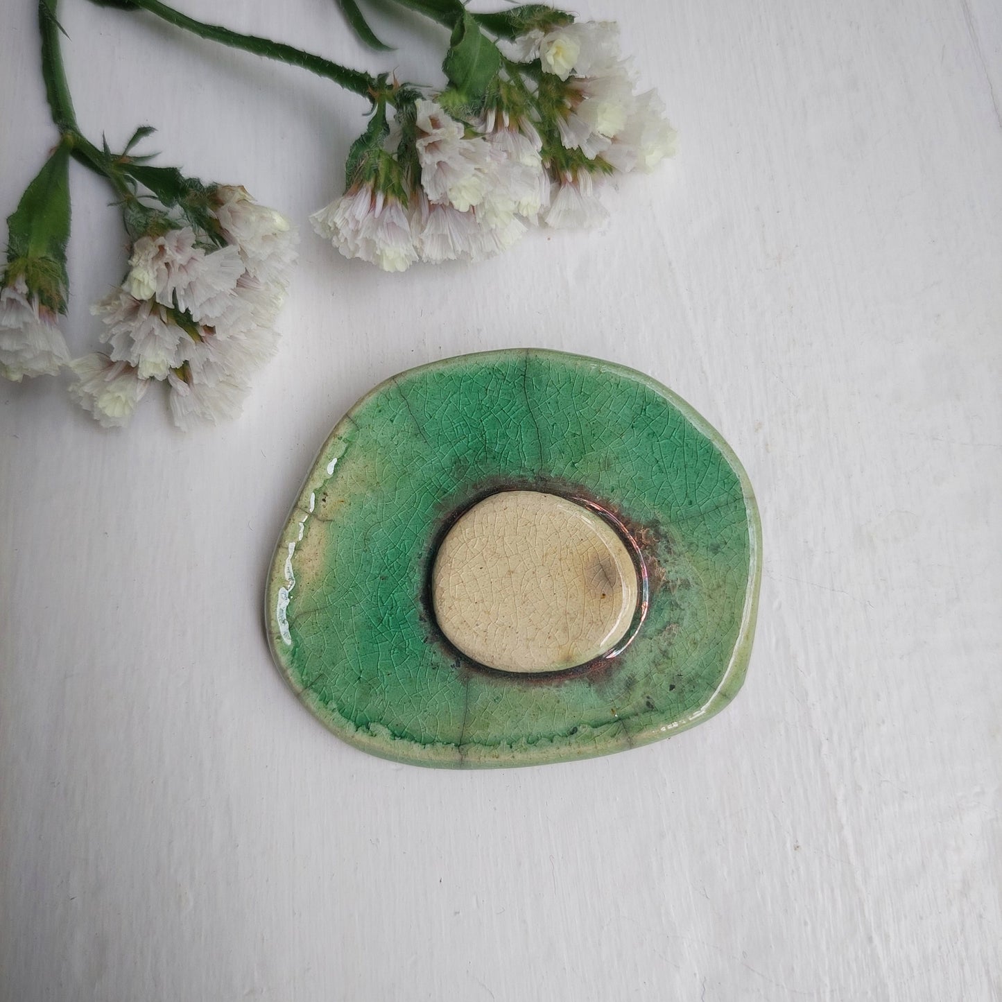 Spilla verde e oro in ceramica verde e bianca Raku con base in metallo.