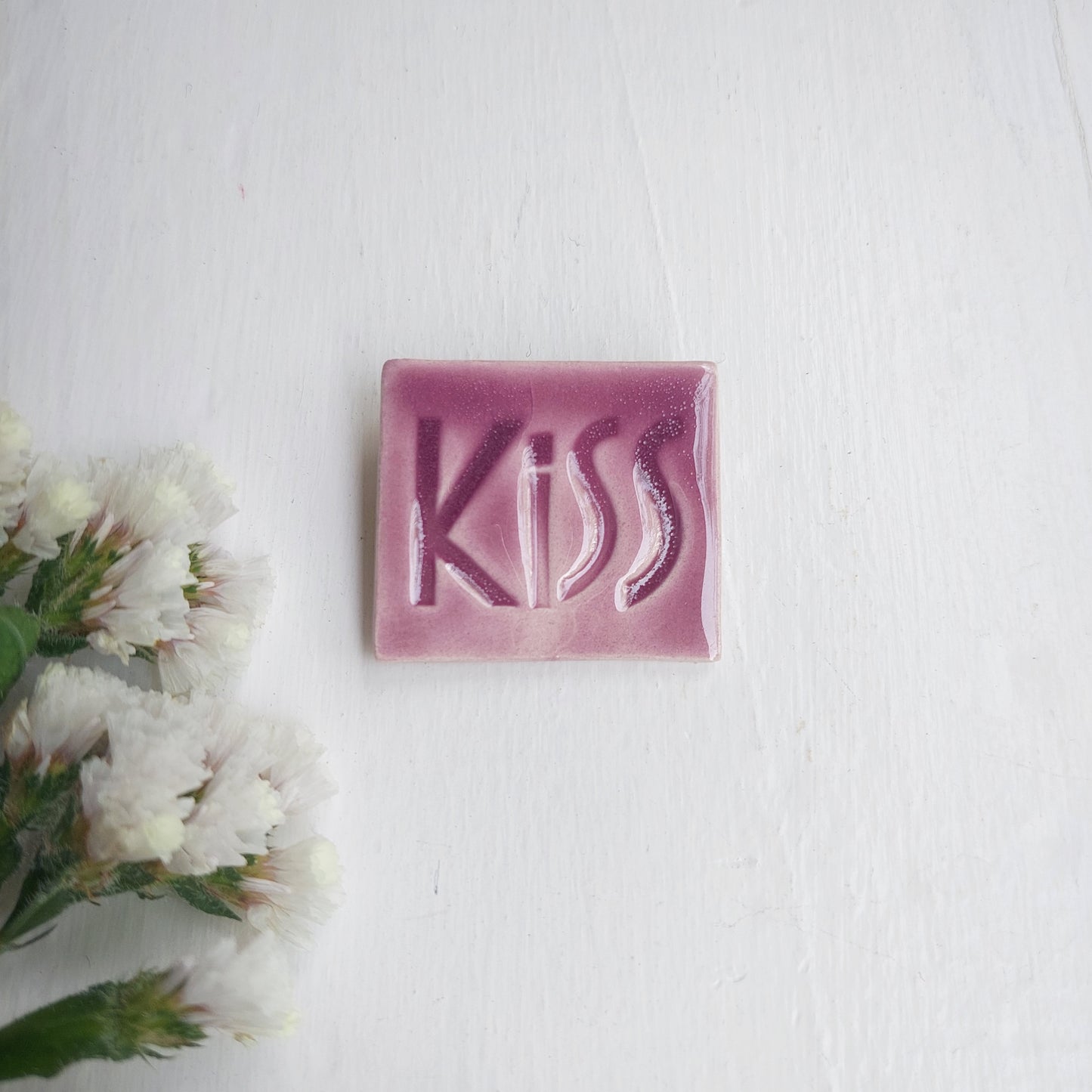 Spilla in ceramica lilla con scritta Kiss