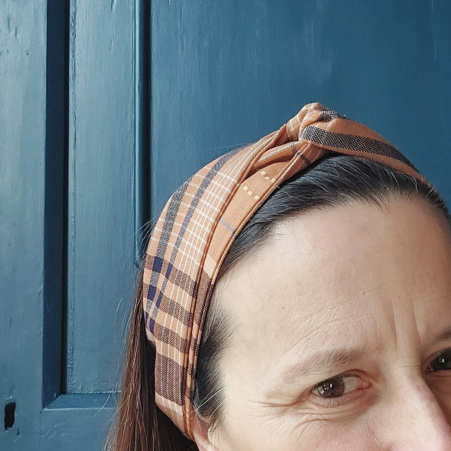 Fascia per capelli realizzata con tessuto scozzese con chiusura ad elastico.