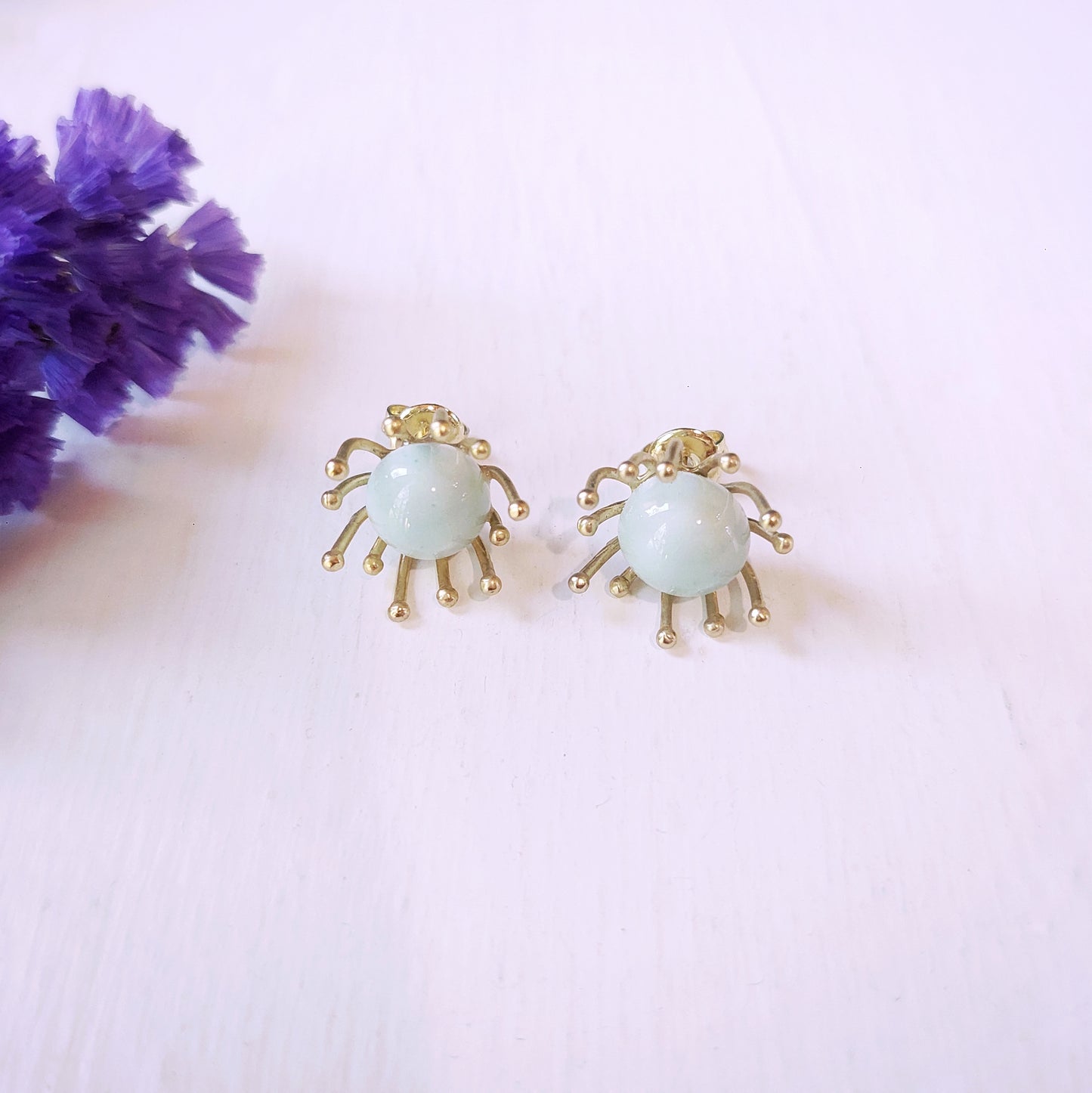 Orecchini Piccoli Raggi con perla in ceramica celeste e metallo color oro.
