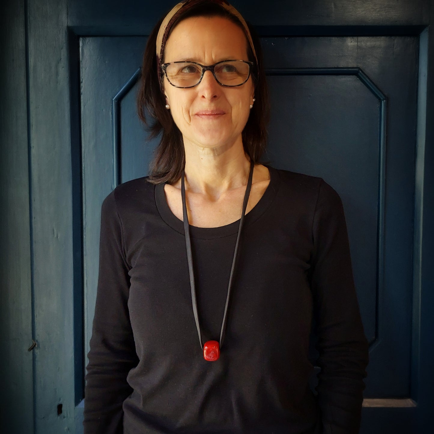 Collana con perla Cubetto in ceramica rossa e laccio nero con chiusura in metallo.