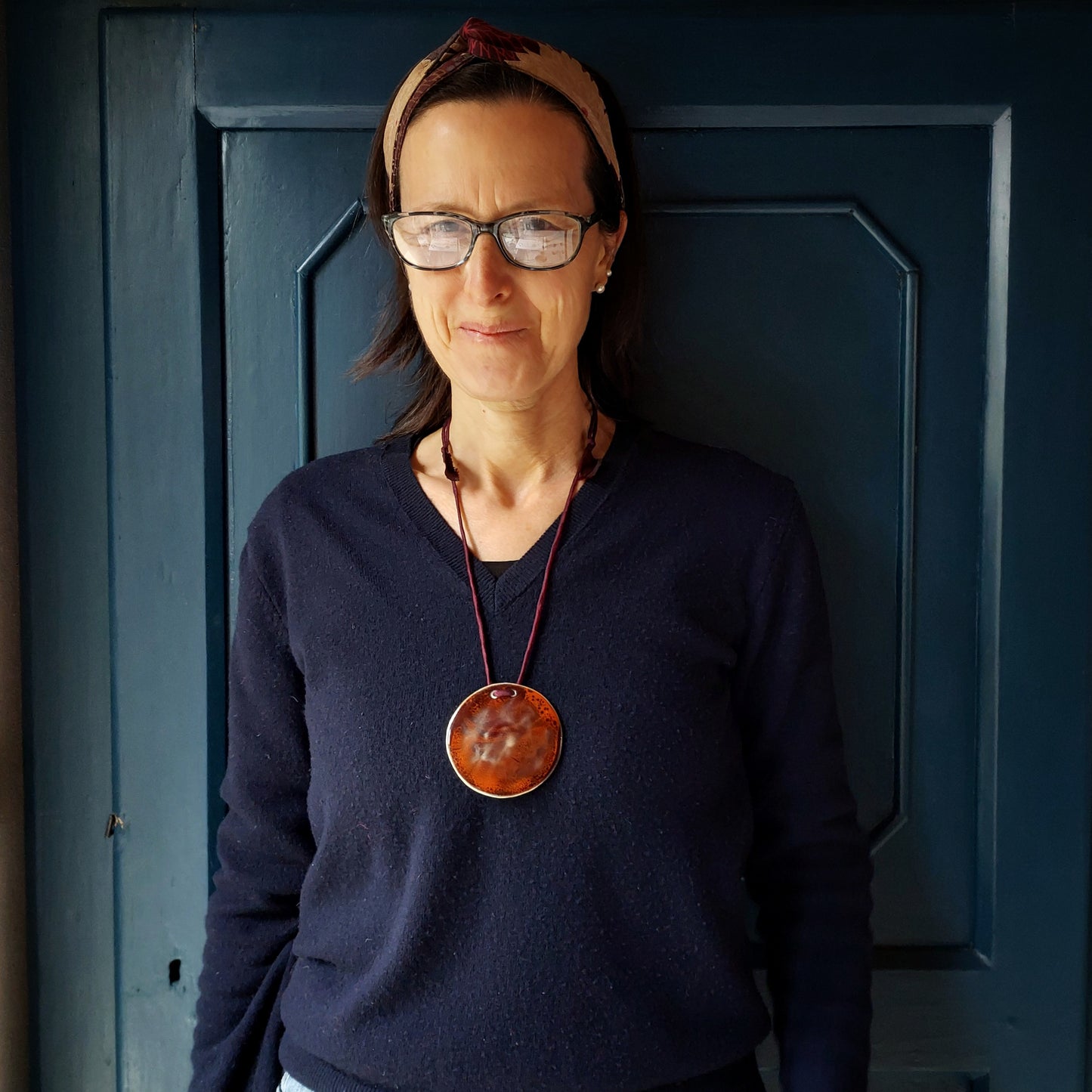 Collana con ciondolo in ceramica rossa e arancione e laccio in seta bordeaux.