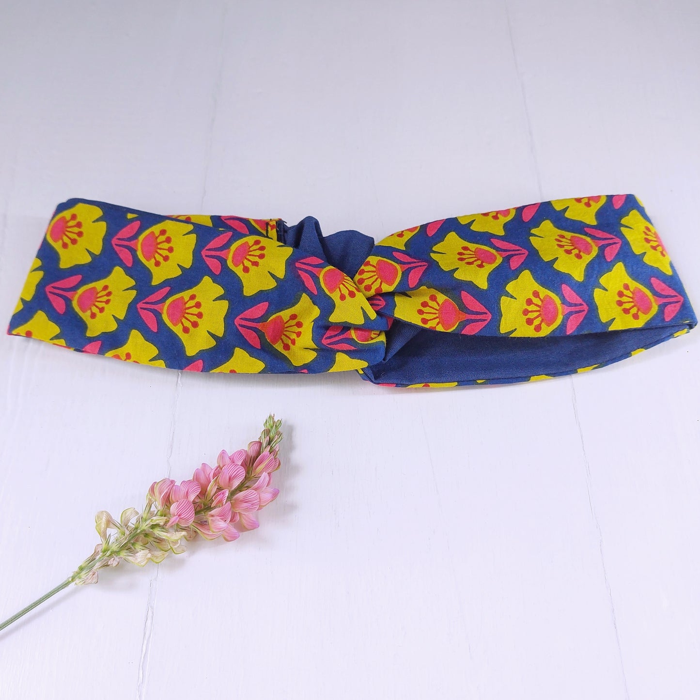 Fascia capelli blu, giallo e fucsia con chiusura ad elastico.