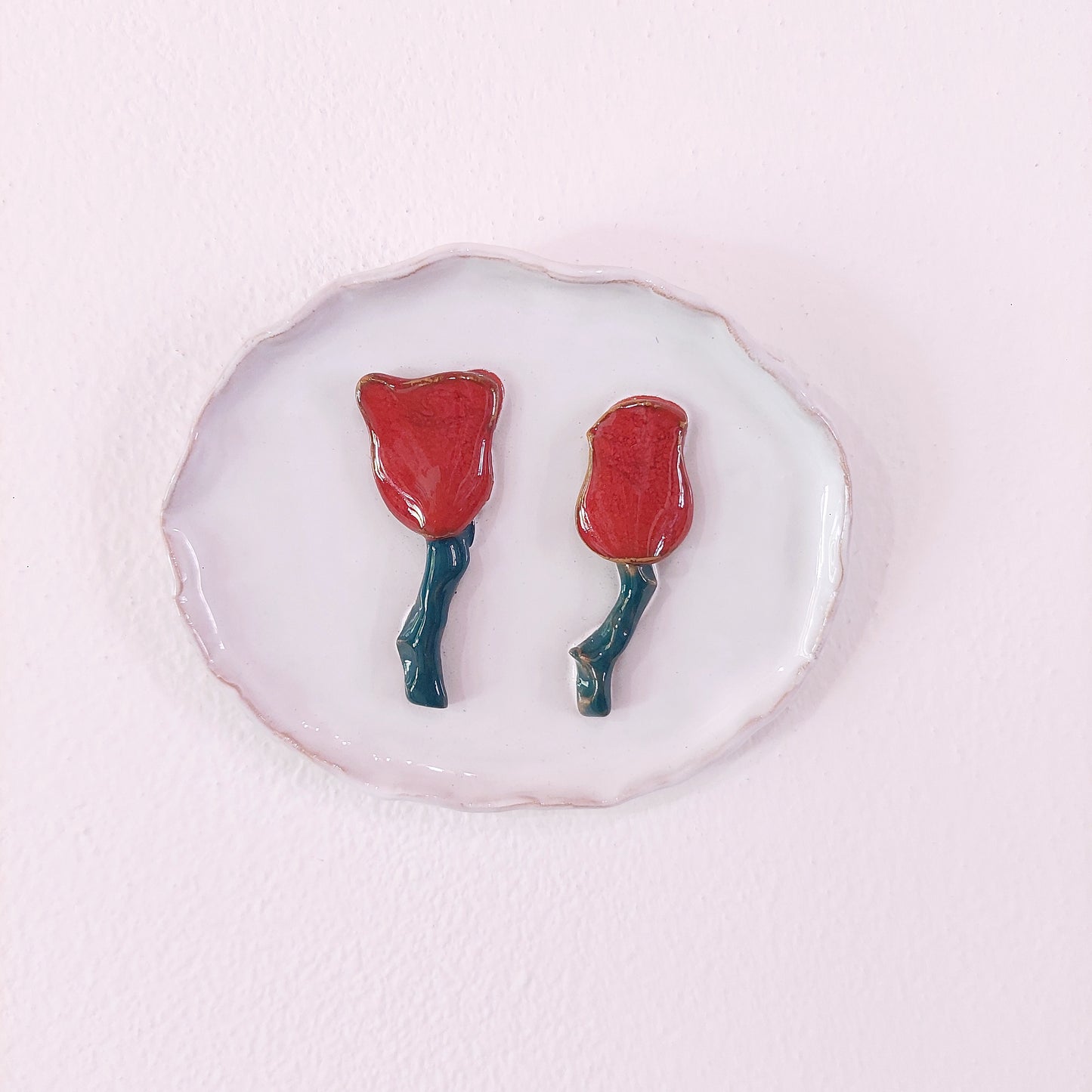 Formella in ceramica bianca con rose rosse.