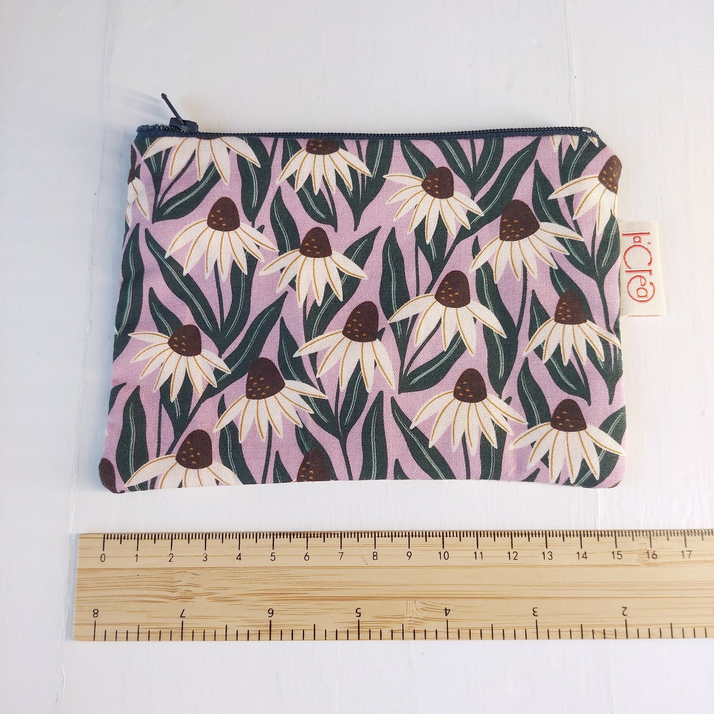 Pochette in cotone viola, bianco e verde con decorazione floreale, foderata.