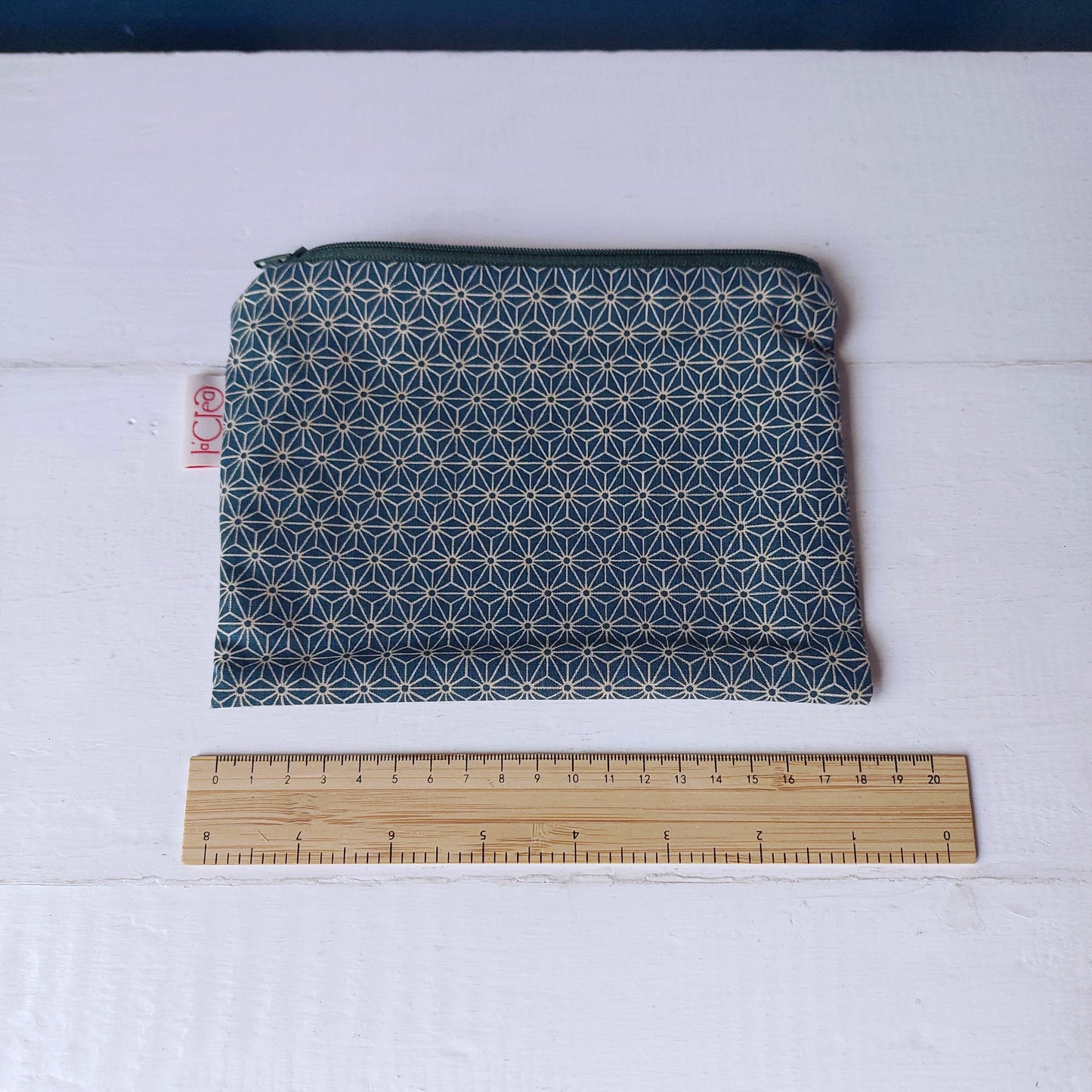 Pochette in cotone verde con decorazione geometrica bianca, foderata.