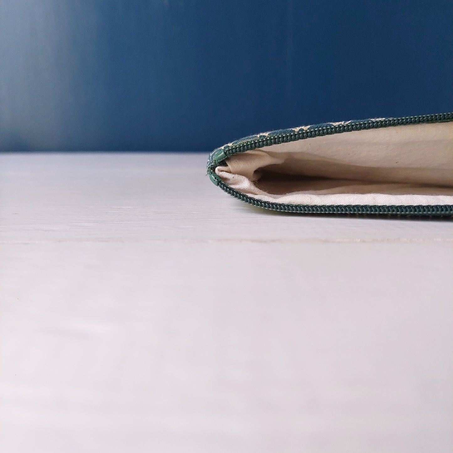 Pochette in cotone verde con decorazione geometrica bianca, foderata.