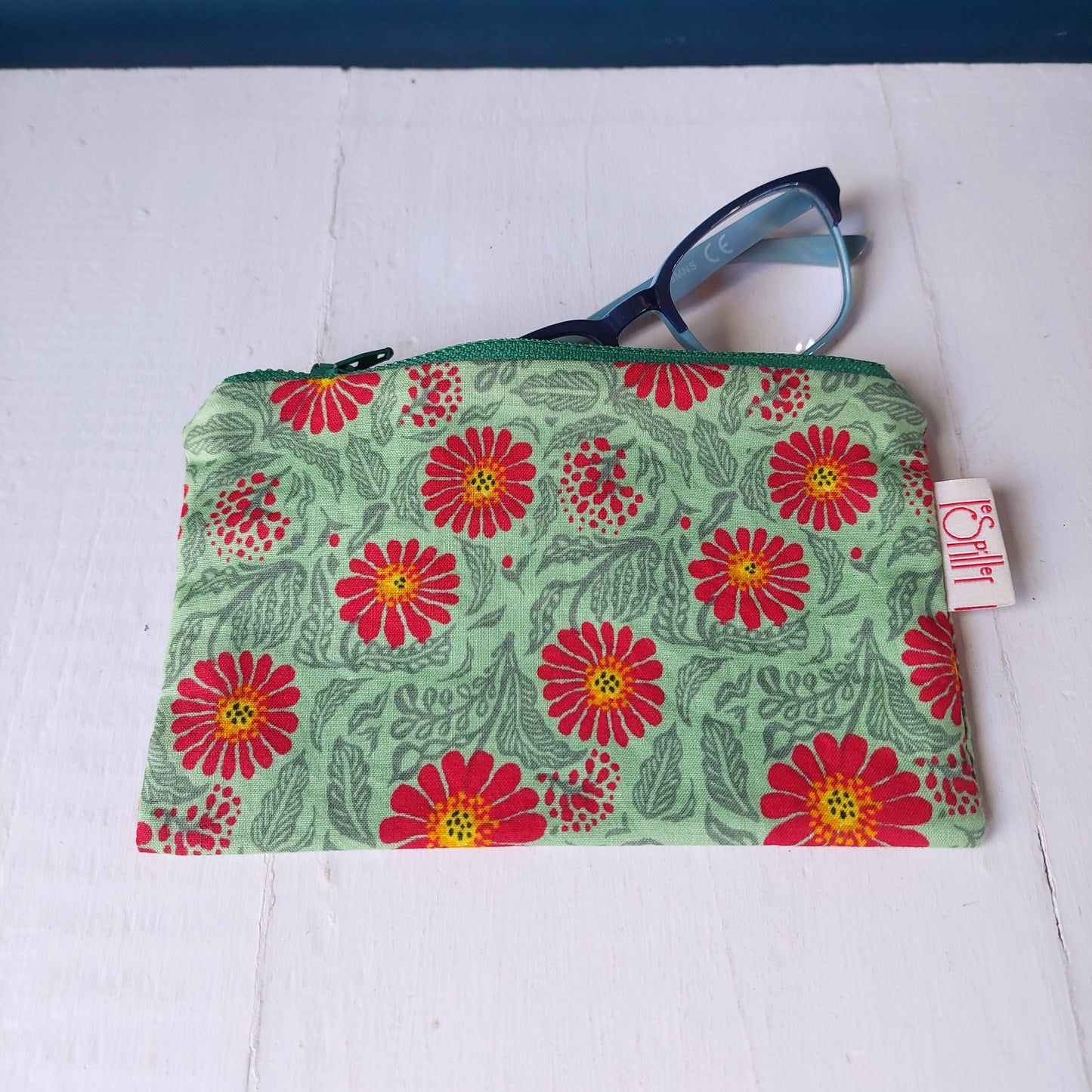Pochette in cotone verde e rossa con decorazione floreale, foderata.