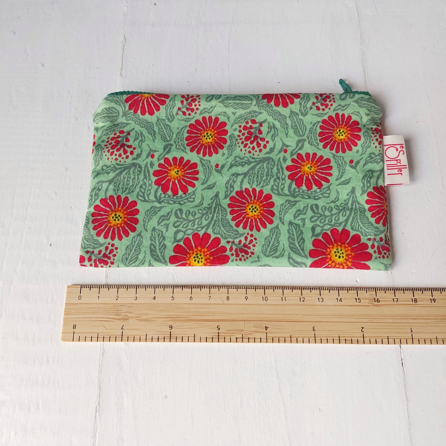 Pochette in cotone verde e rossa con decorazione floreale, foderata.