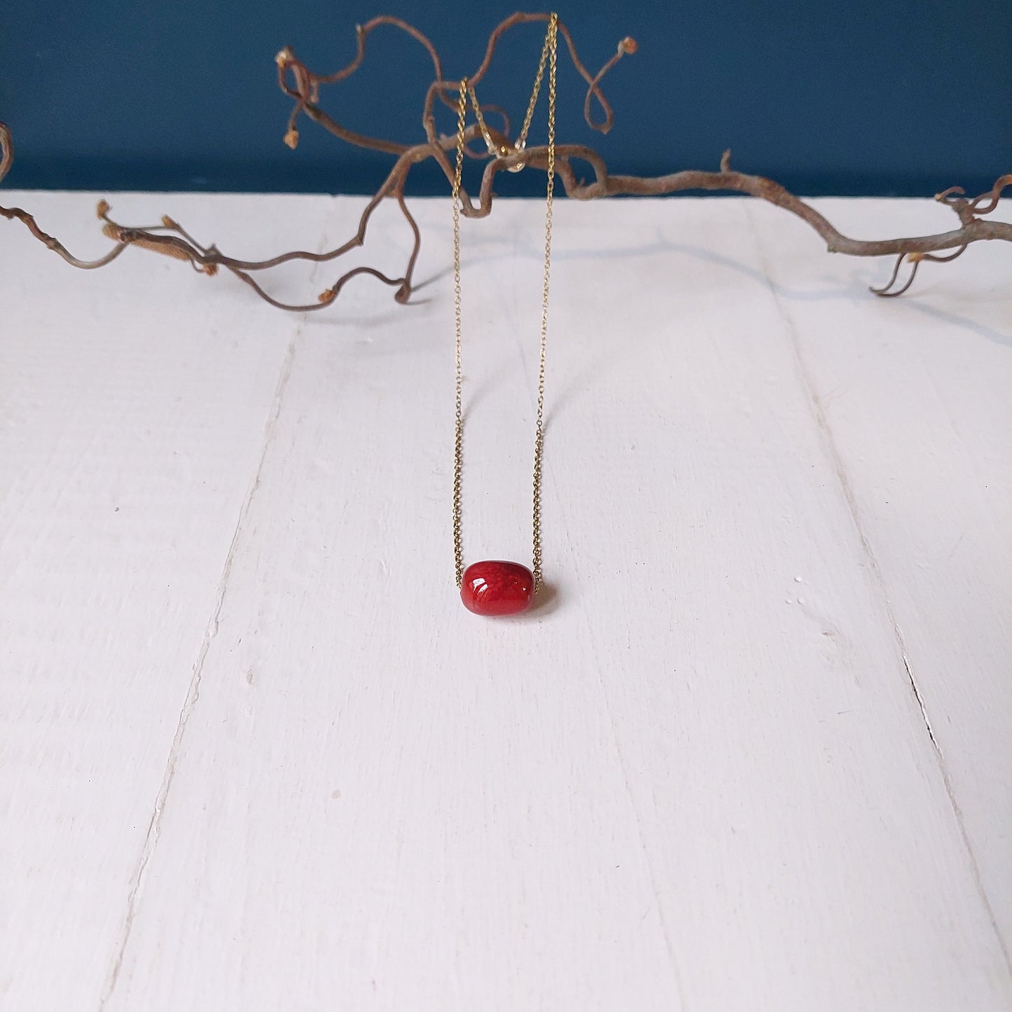 Collana girocollo con perla in ceramica rossa e catena color oro, in tre varianti.