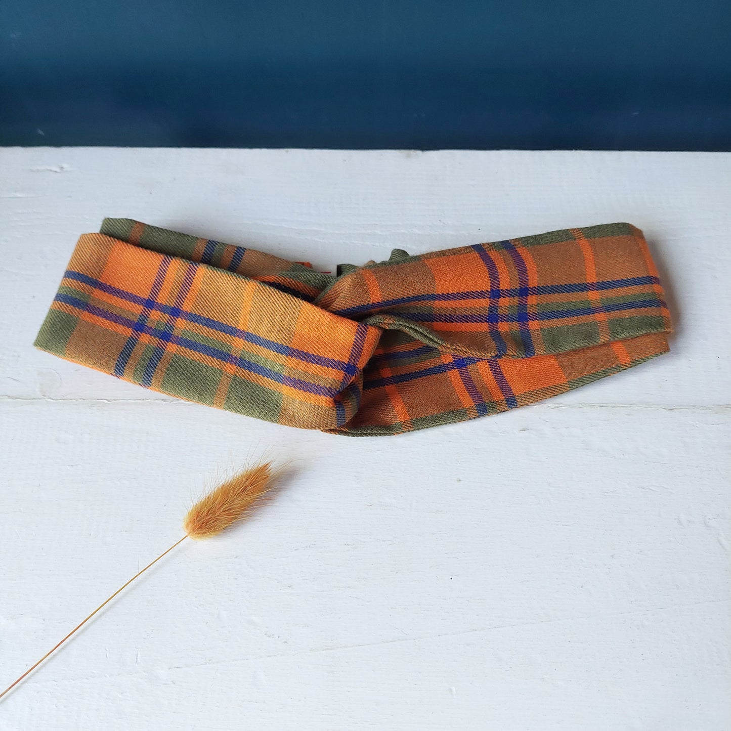 Fascia per capelli realizzata con tessuto scozzese con chiusura ad elastico.