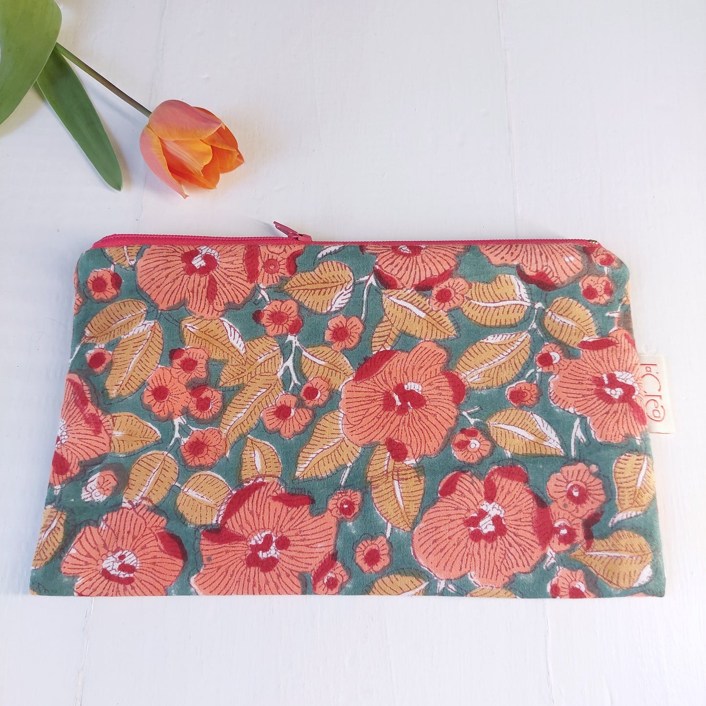 Pochette in cotone verde e rossa con decorazione floreale, foderata.