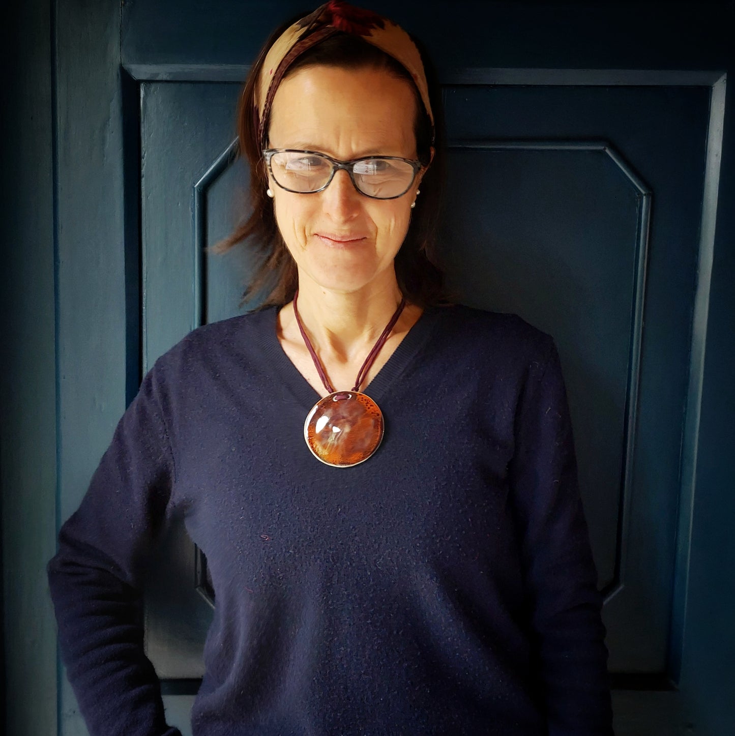 Collana con ciondolo in ceramica rossa e arancione e laccio in seta bordeaux.