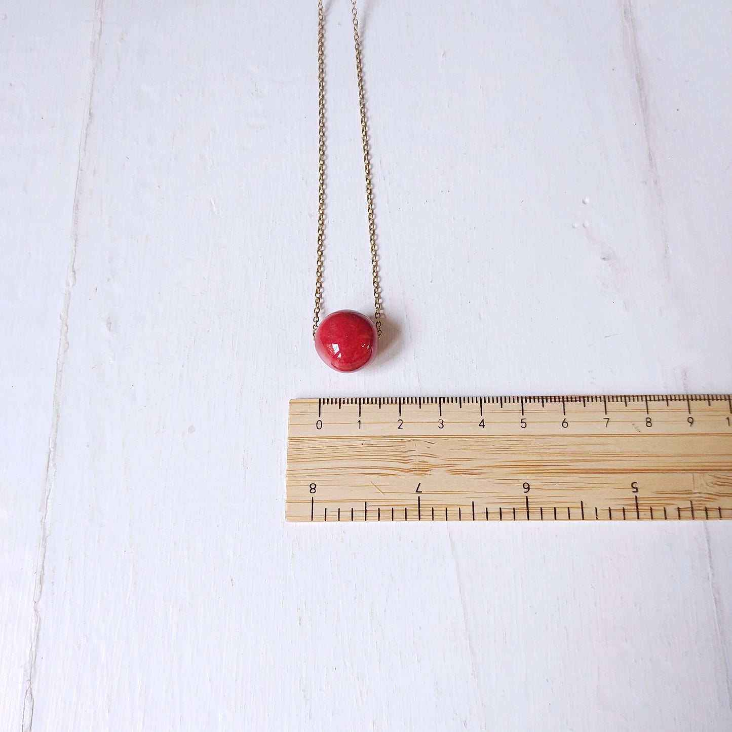 Collana girocollo con perla in ceramica rossa e catena color oro, in tre varianti.