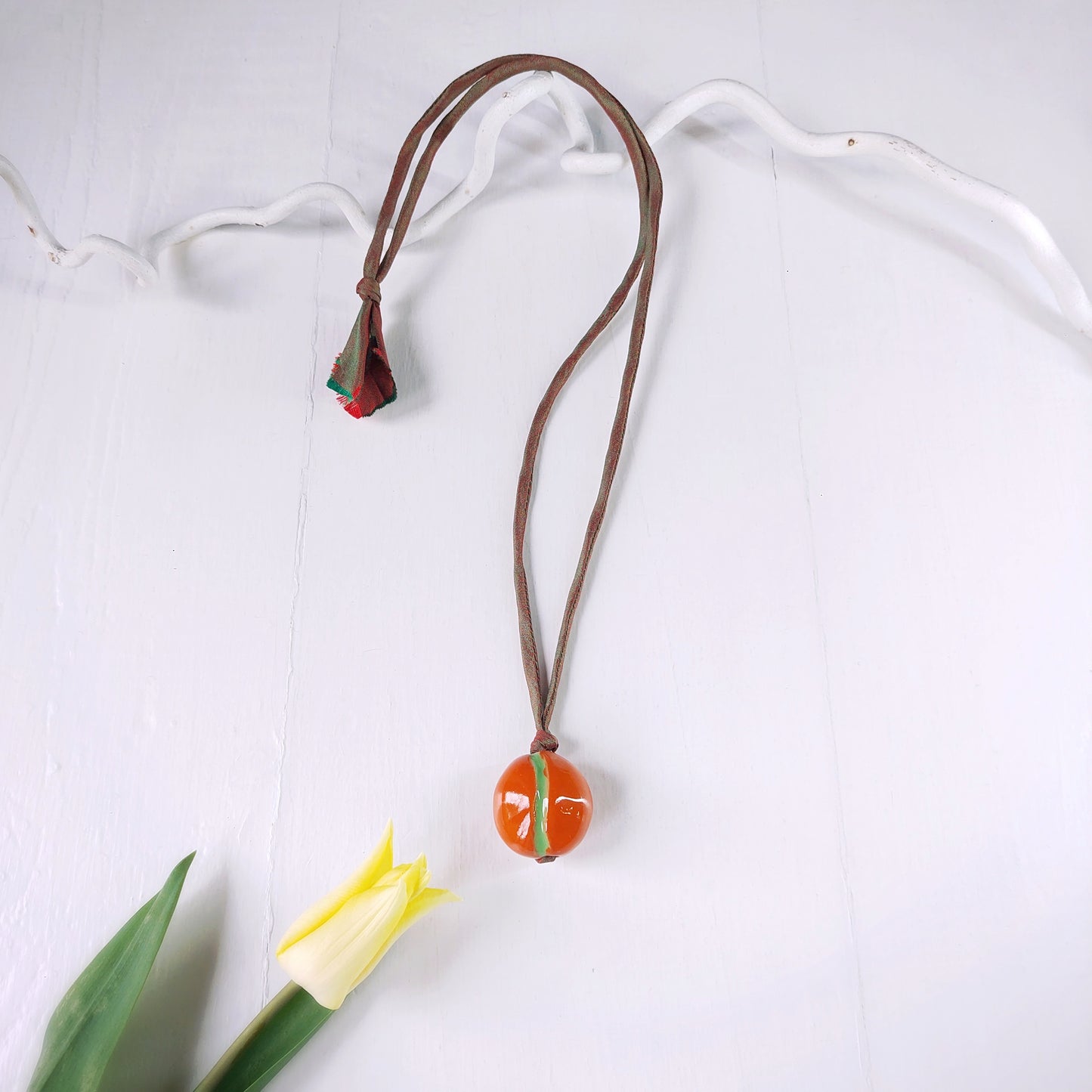 Collana donna con perla in ceramica arancione e verde e laccio in seta verde.