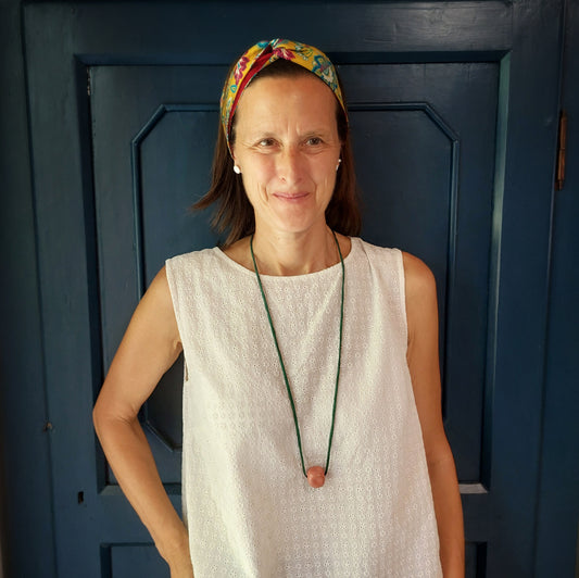 Collana con perla in ceramica rosa e laccio in seta verde .