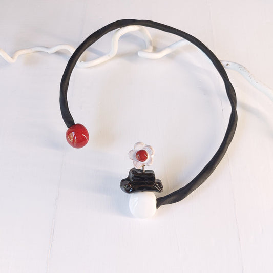 Girocollo Mary Poppins con perle rosse, bianche e nere in ceramica e accessorio rigido in metallo ricoperto da tessuto nero.