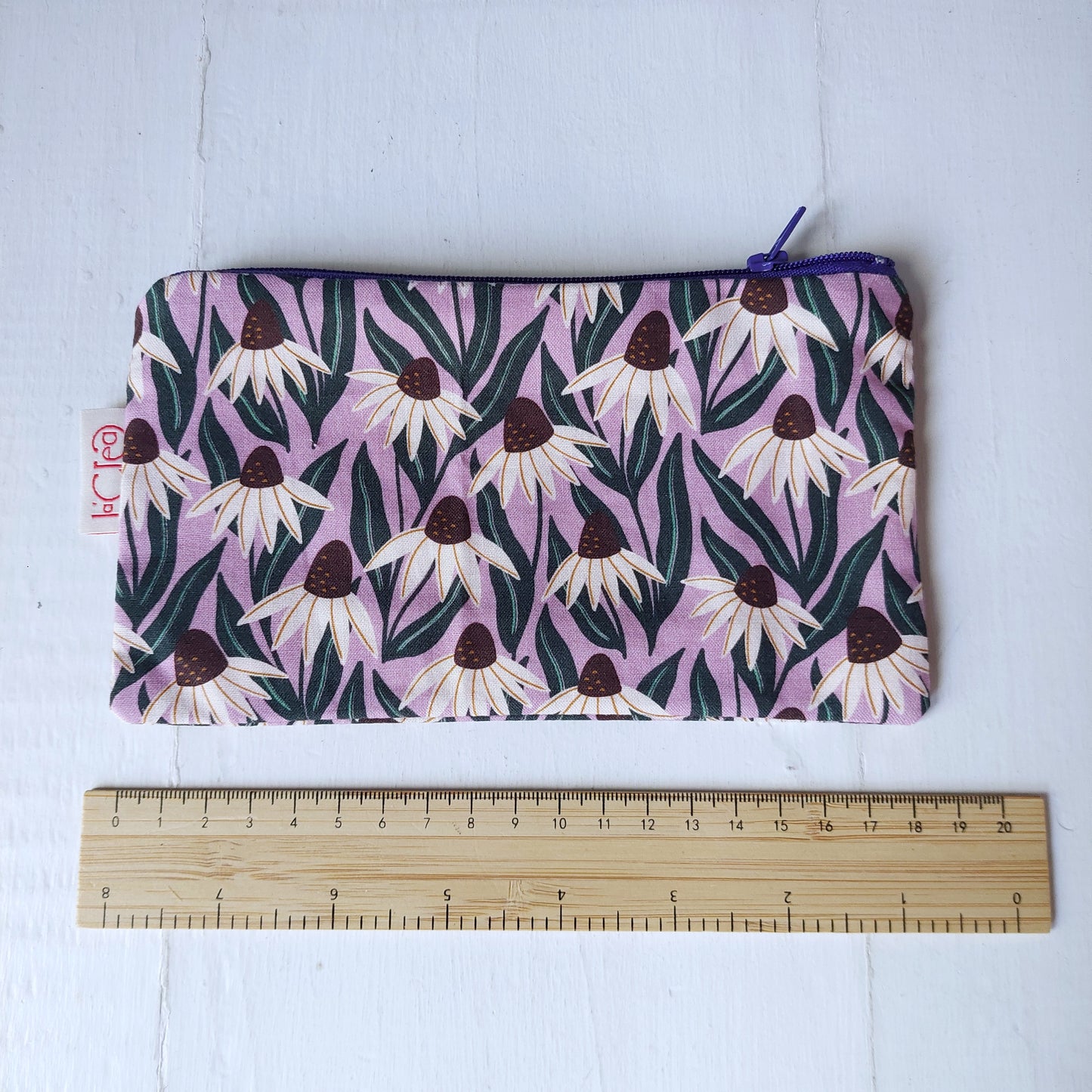 Pochette in cotone viola, bianco e verde con decorazione floreale, foderata.