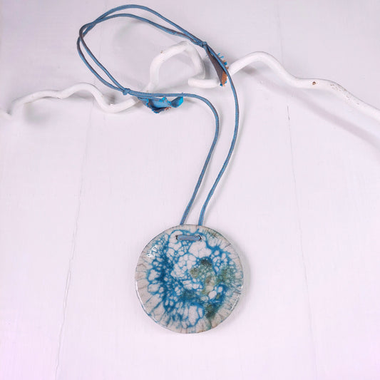 Collana con perla in ceramica bianca e azzurra e laccio in seta azzurra.
