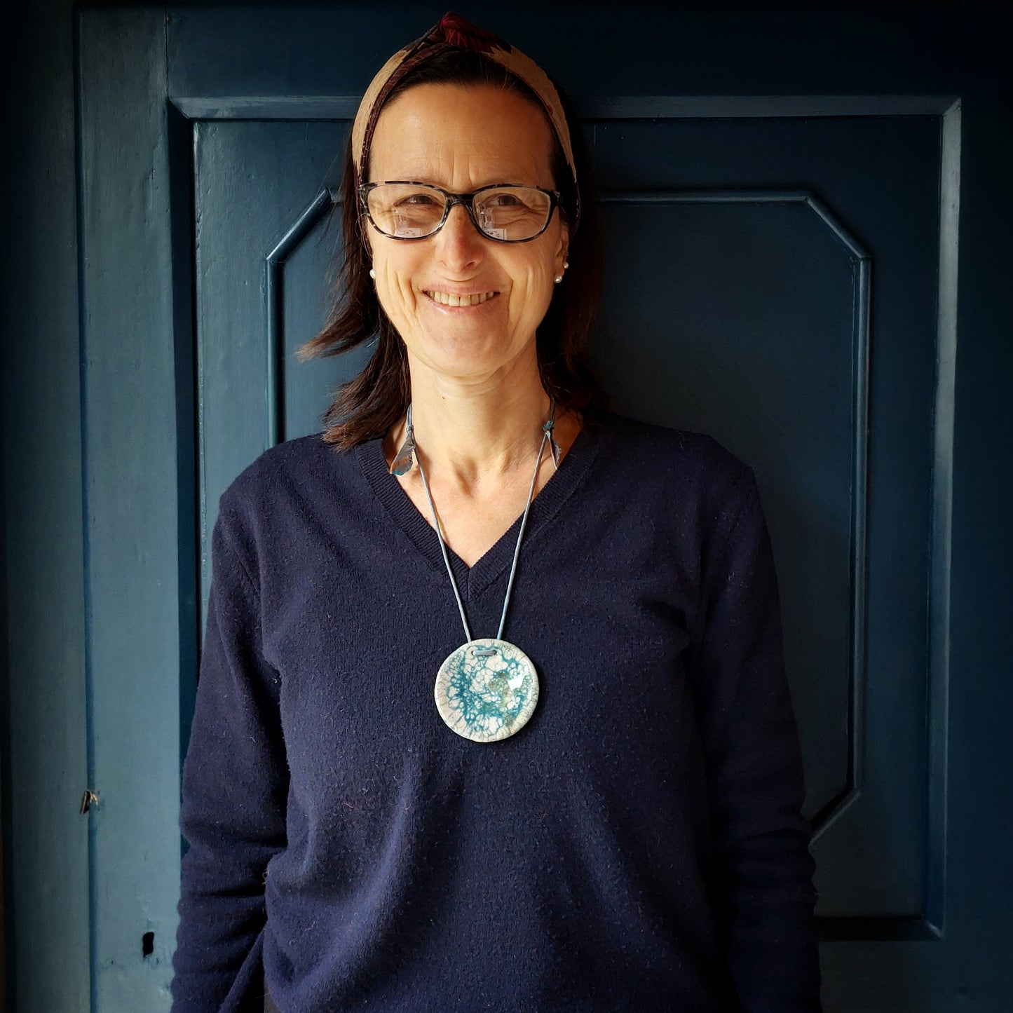 Collana con perla in ceramica bianca e azzurra e laccio in seta azzurra.