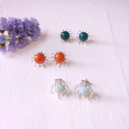 Orecchini Piccoli Raggi con perla in ceramica arancione e metallo color argento.