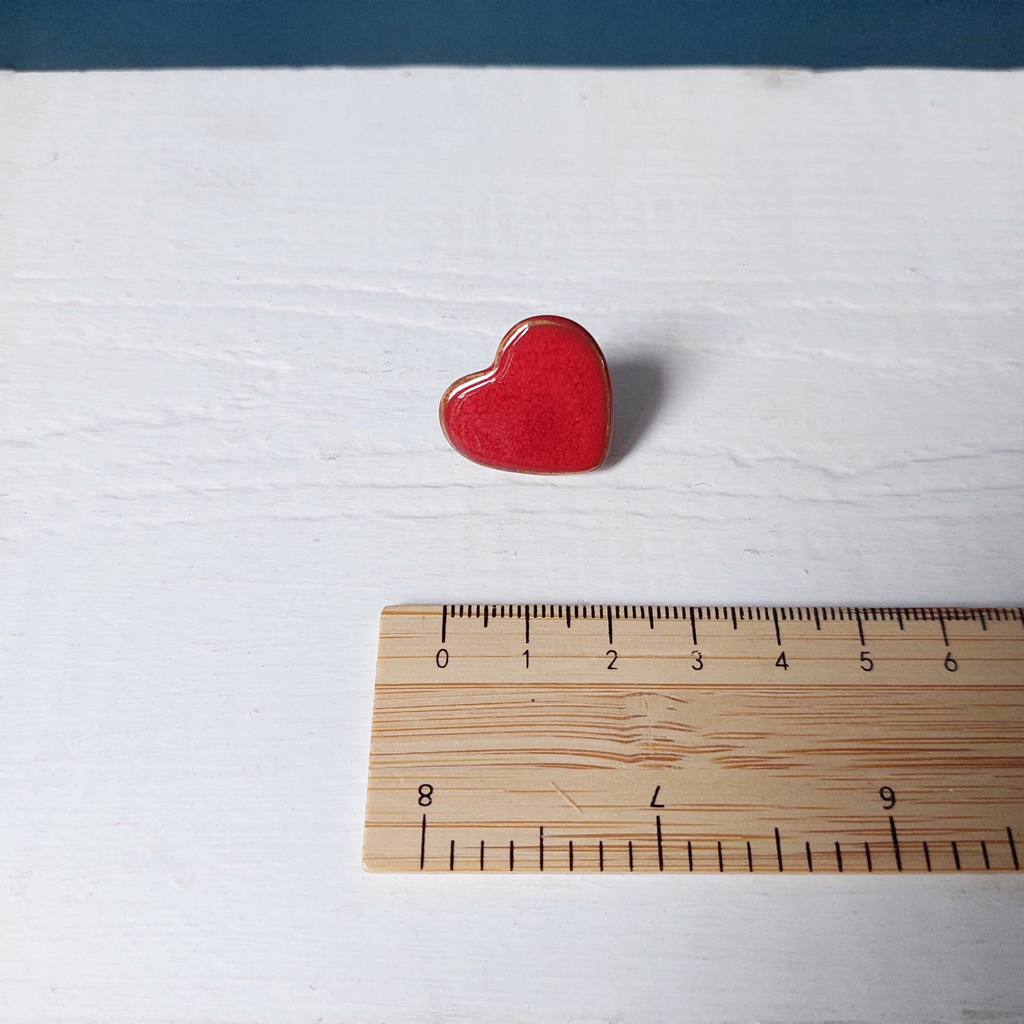 Spilla cuore piccola, in ceramica rossa con retro in metallo.