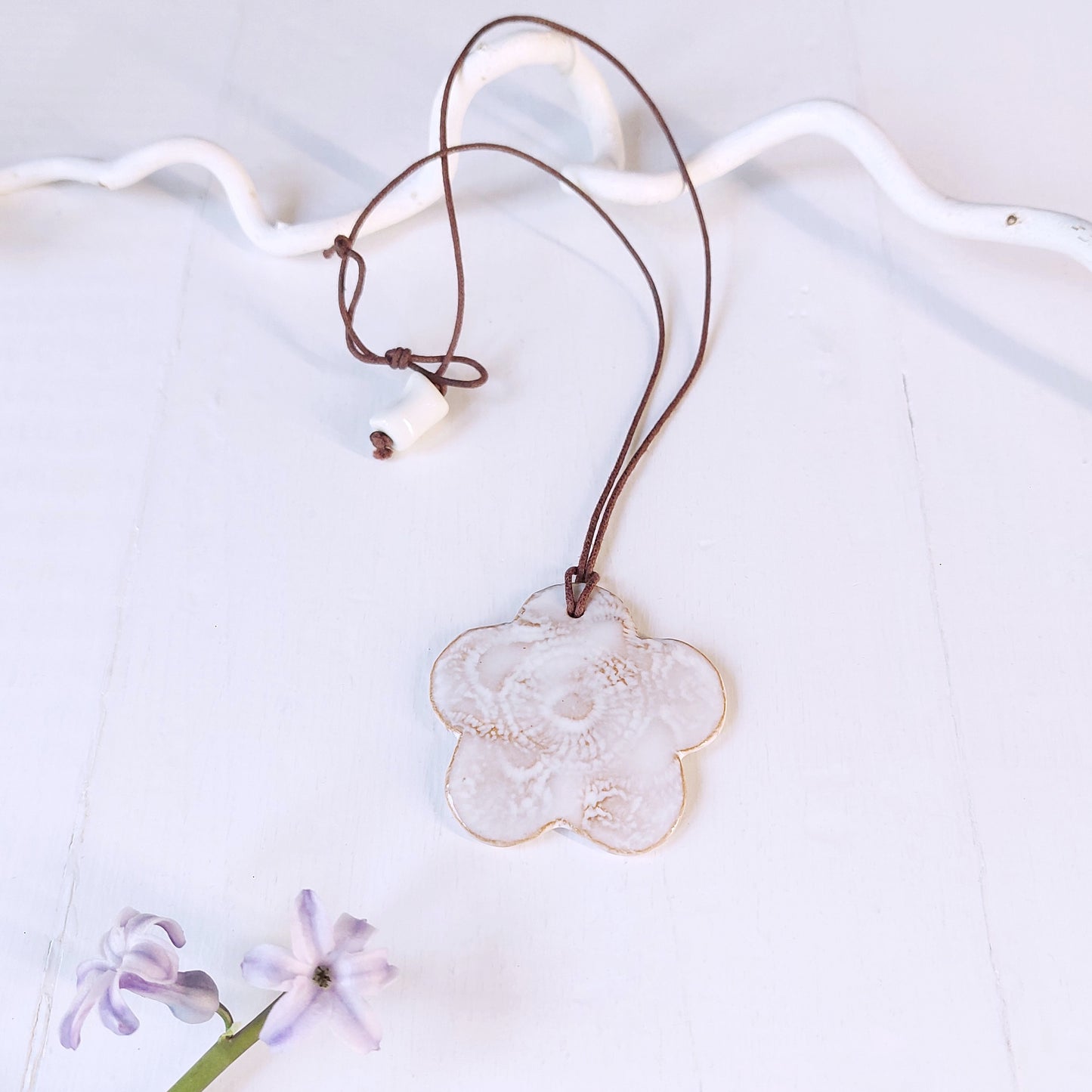 Collana con fiore in ceramica  bianca e laccio marrone.