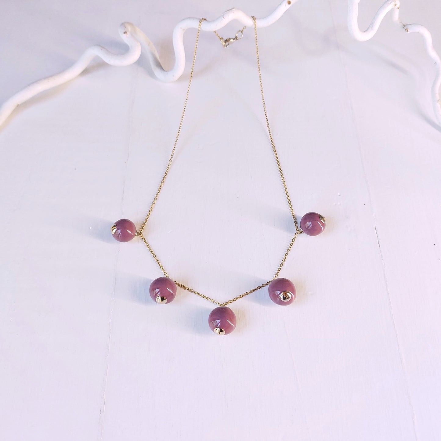 Collana Piccoli Mondi con perle viola e catena color oro.