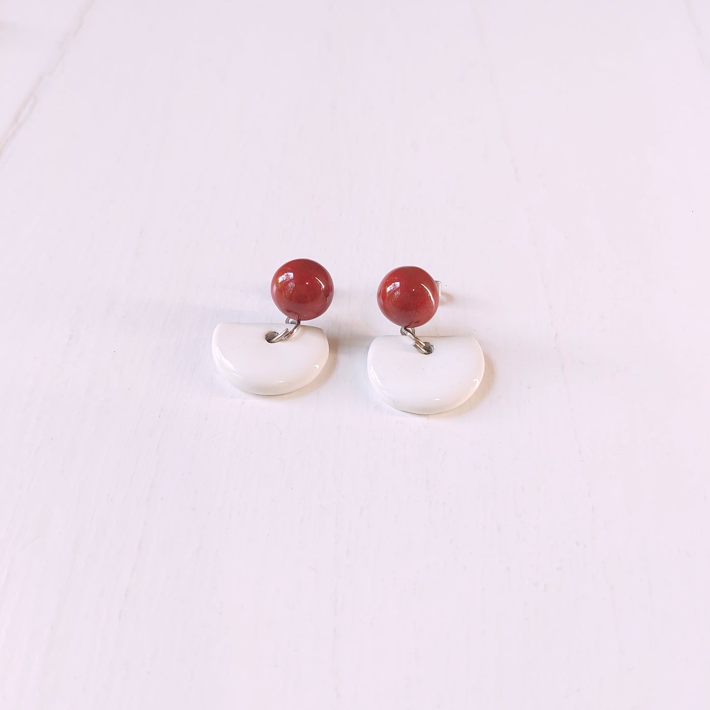 Orecchini pendenti in ceramica rossa bombata e ceramica bianca, in cinque varianti colore.