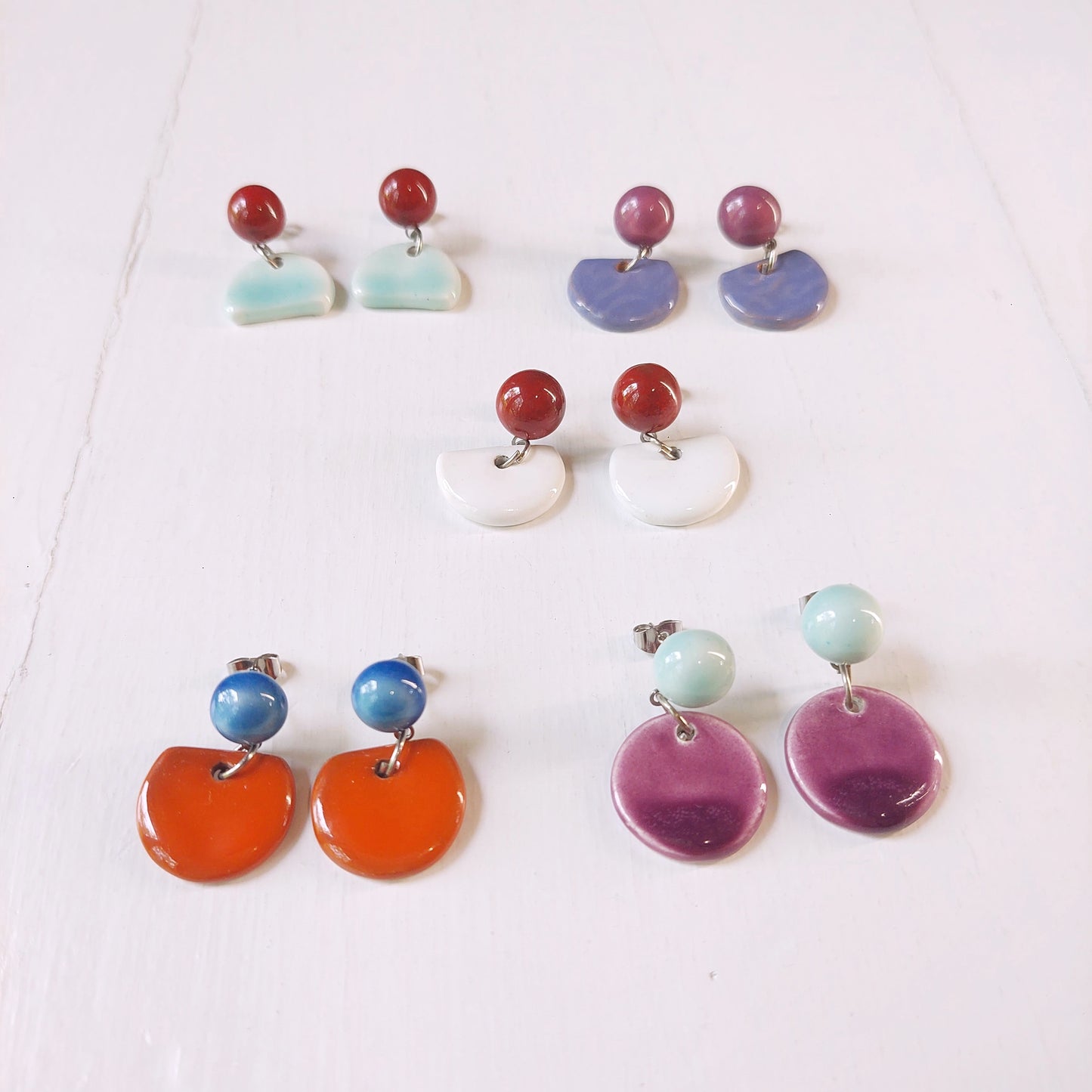 Orecchini pendenti in ceramica rossa bombata e ceramica bianca, in cinque varianti colore.