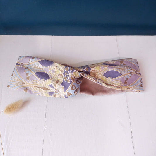 Fascia per capelli con tessuto fantasia viola celeste, bianca e tessuto rosa.