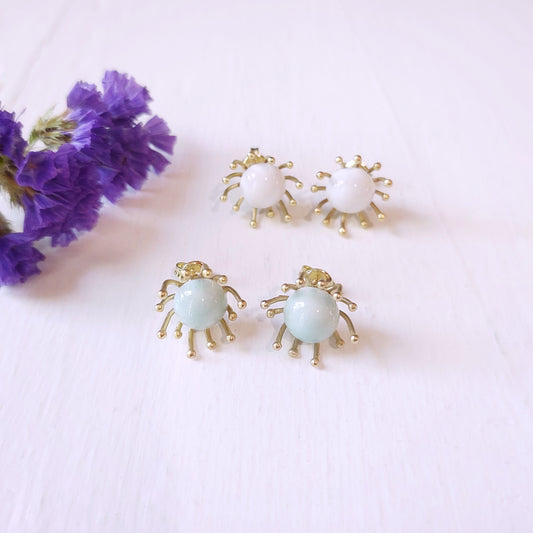 Orecchini Piccoli Raggi con perla in ceramica celeste e metallo color oro.