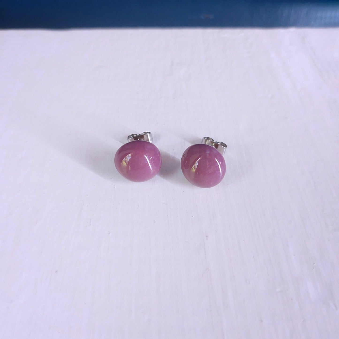 Orecchini bombati con perla in ceramica rossa in quattro varianti colore.
