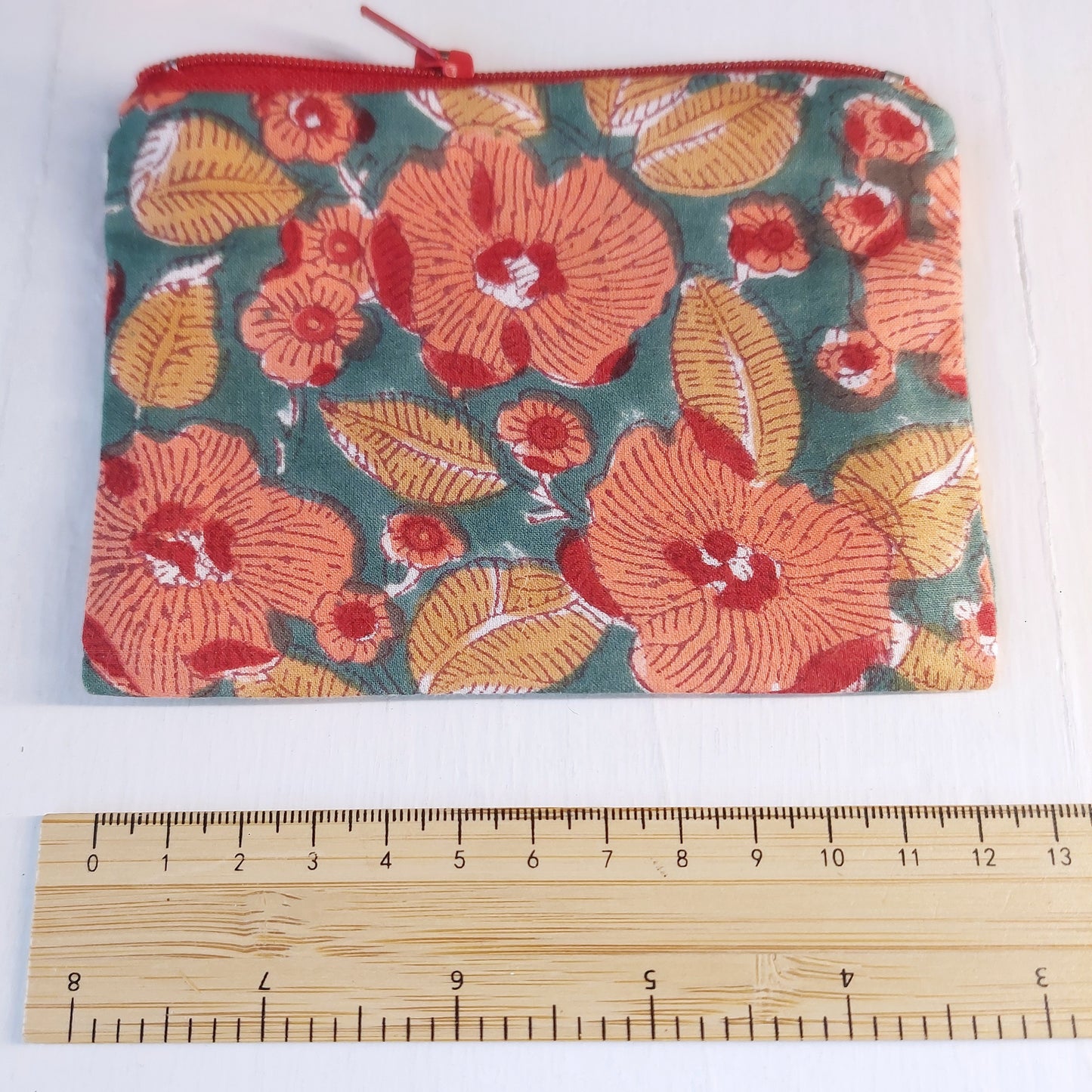Pochette in cotone verde e rossa con decorazione floreale, foderata.