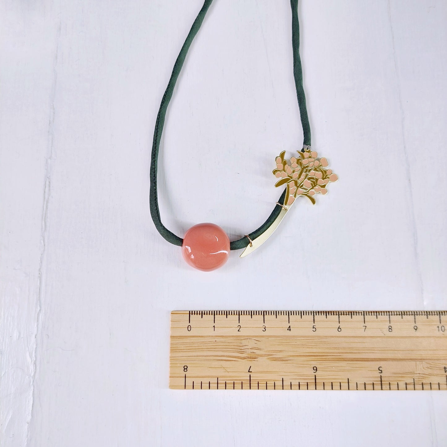 Collana donna con perla in ceramica rosa, alberello in metallo dorato smaltato e laccio in seta verde.