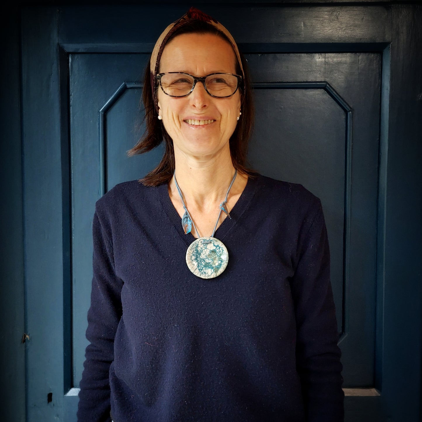 Collana con perla in ceramica bianca e azzurra e laccio in seta azzurra.