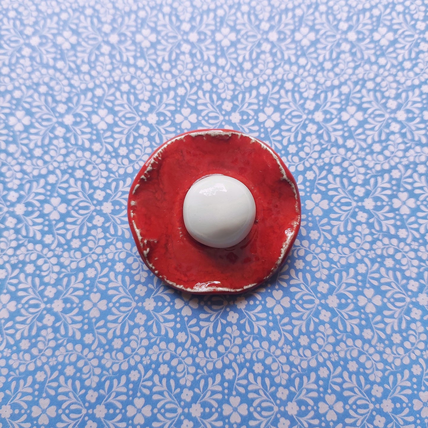 Spilla Bon Bon in ceramica rossa e bianca, con base in metallo.