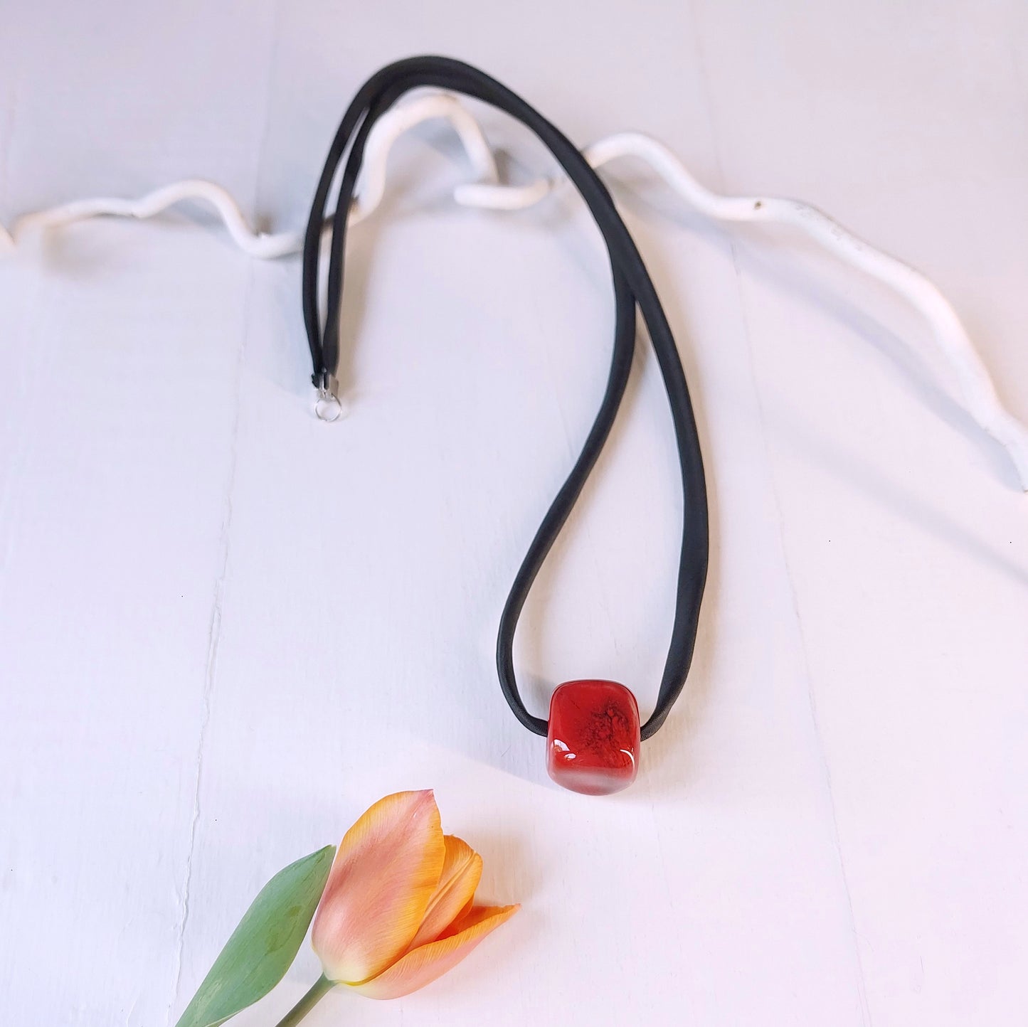 Collana con perla Cubetto in ceramica rossa e laccio nero con chiusura in metallo.