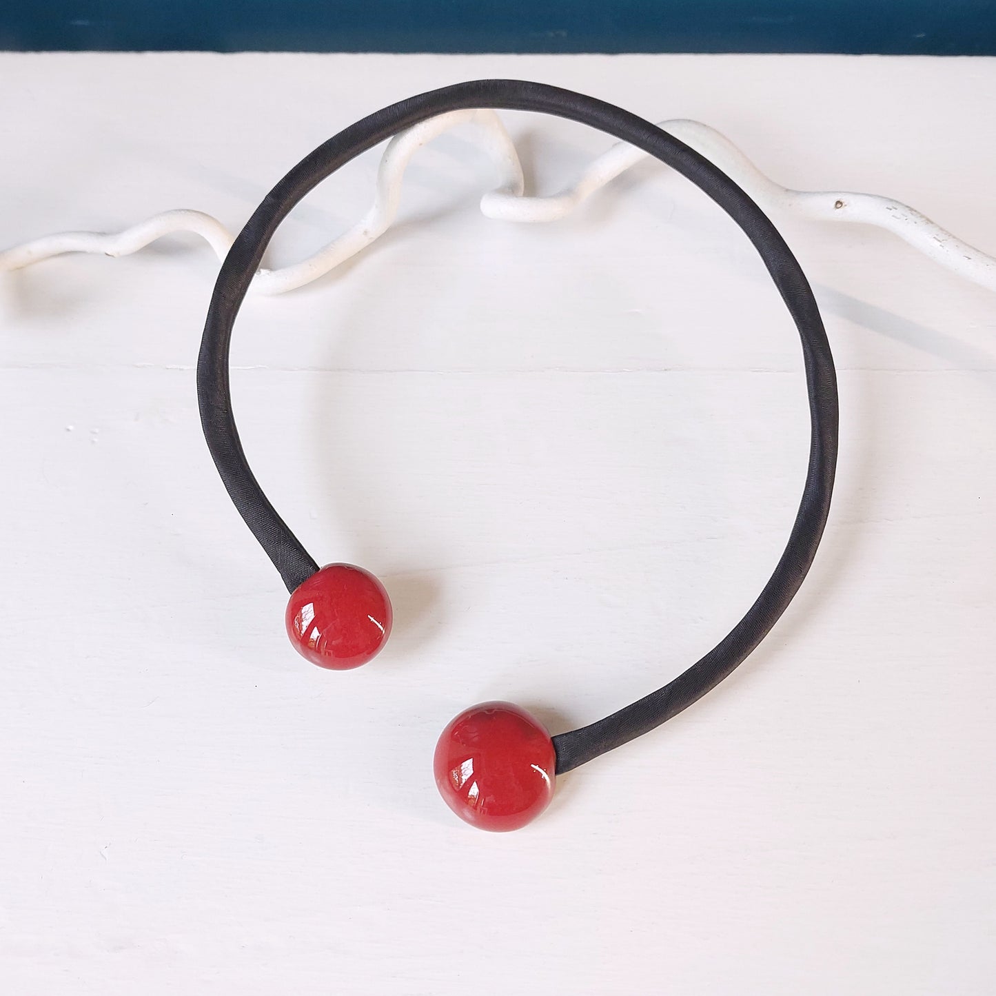 Girocollo con perle rosse quadrate in ceramica e accessorio rigido in metallo ricoperto di tessuto nero, in tre varianti colore.