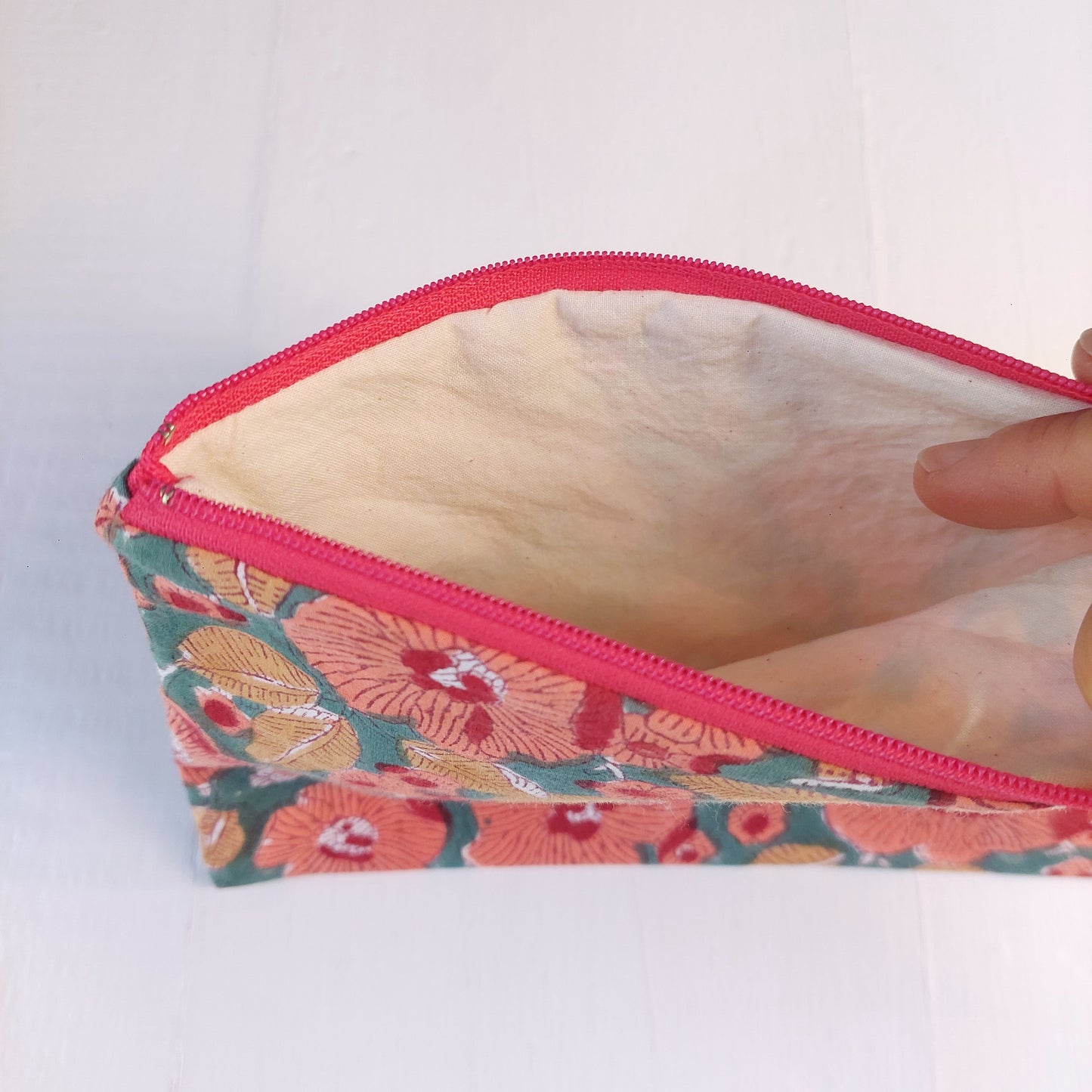 Pochette in cotone verde e rossa con decorazione floreale, foderata.