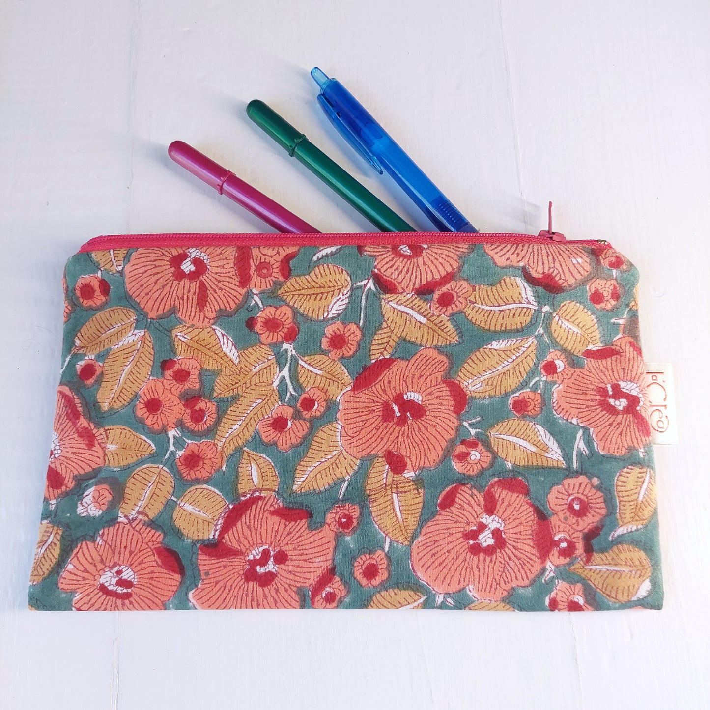 Pochette in cotone verde e rossa con decorazione floreale, foderata.
