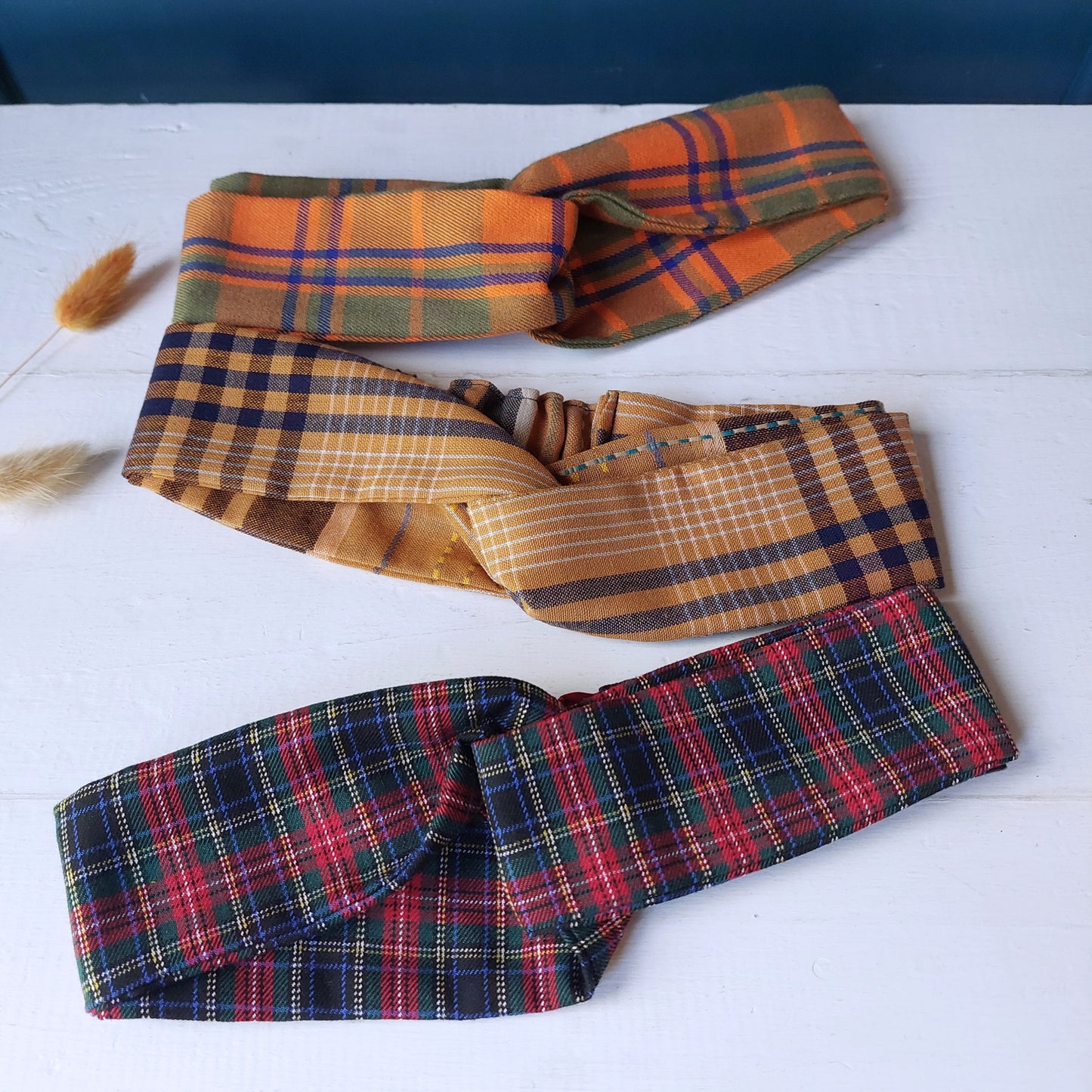 Fascia per capelli realizzata con tessuto scozzese con chiusura ad elastico.