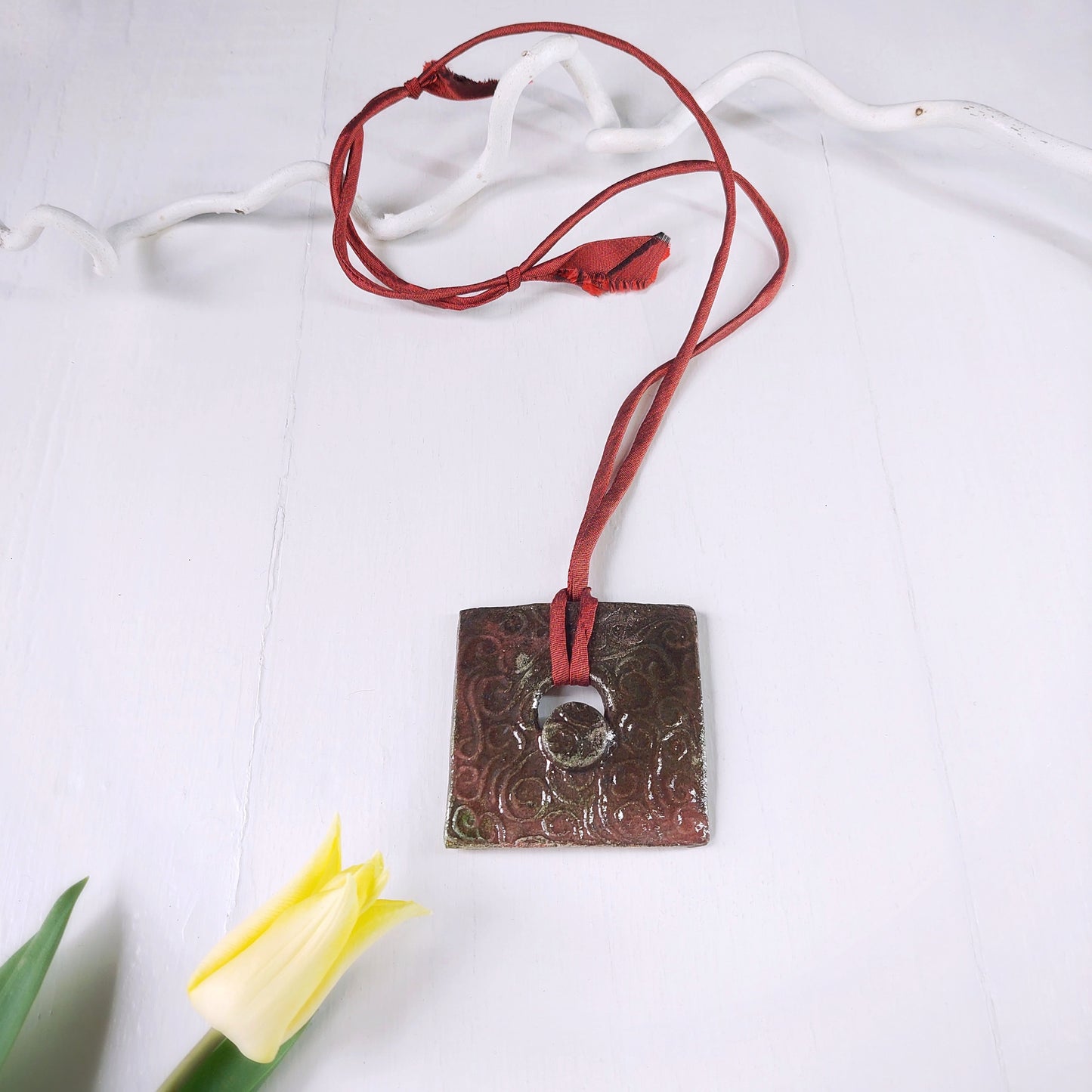 Collana con ciondolo quadrato in ceramica Raku color rame e laccio in seta bordeaux.