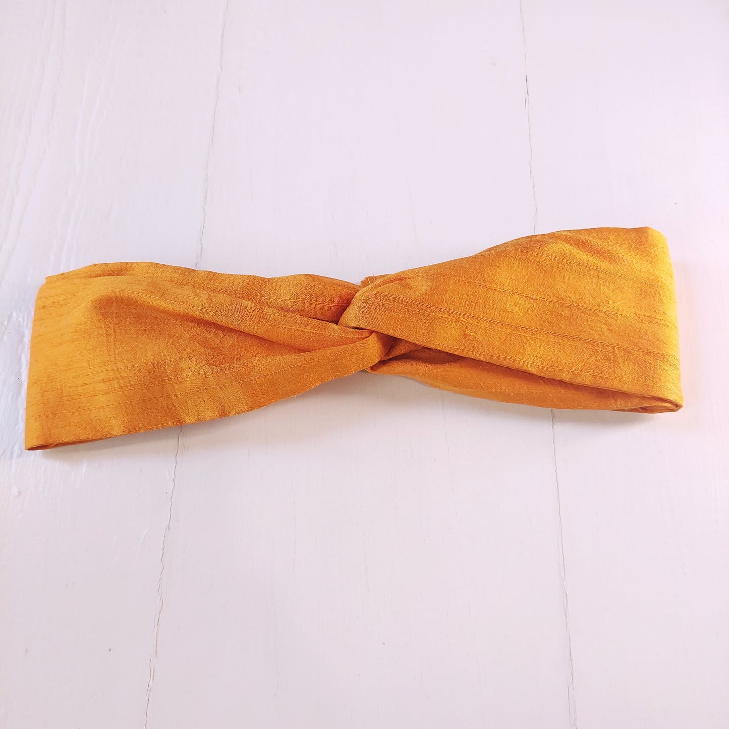 Fascia con seta arancione e chiusura ad elastico.