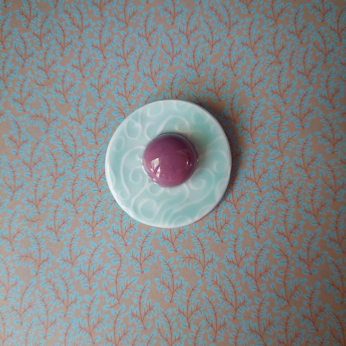 Spilla Bon Bon in ceramica rossa e bianca, con base in metallo.