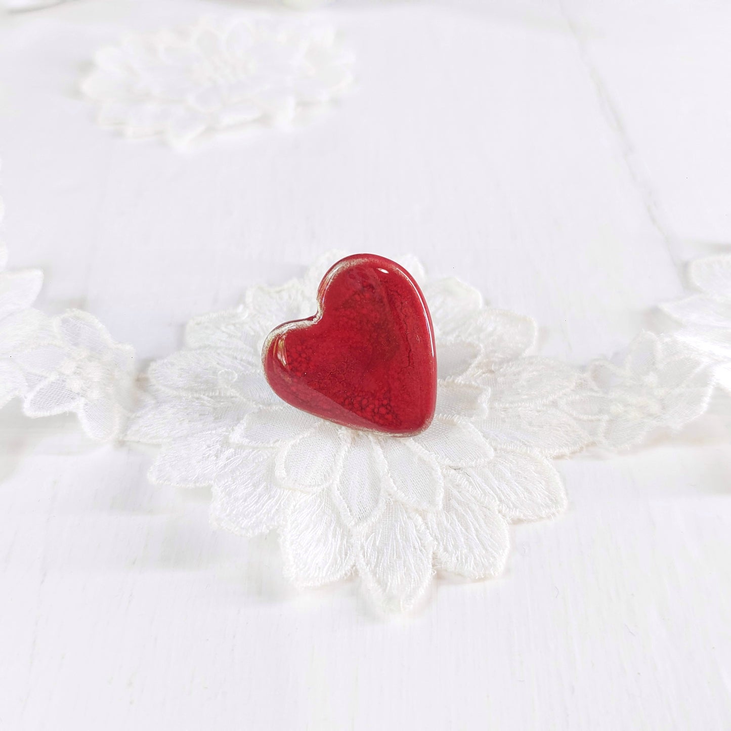 Spilla cuore piccola con bordo bianco, in ceramica rossa con retro in metallo.