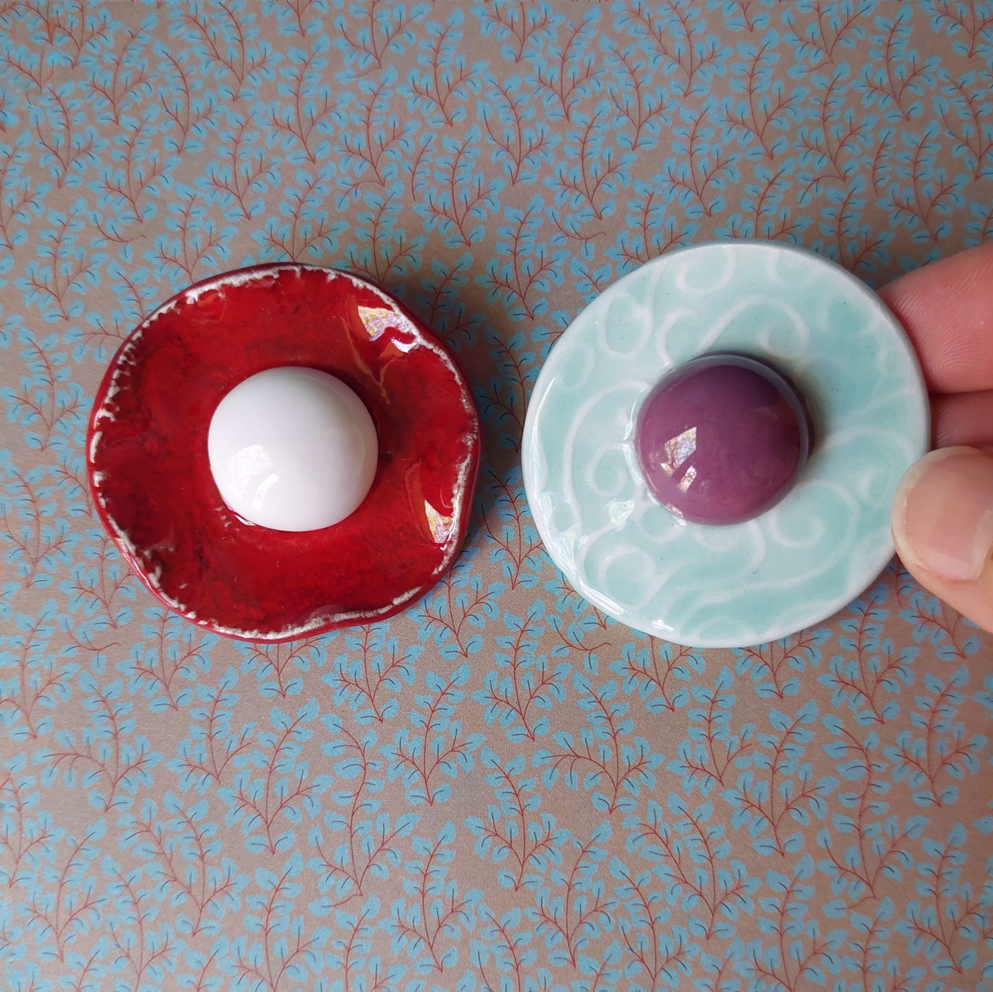 Spilla Bon Bon in ceramica rossa e bianca, con base in metallo.