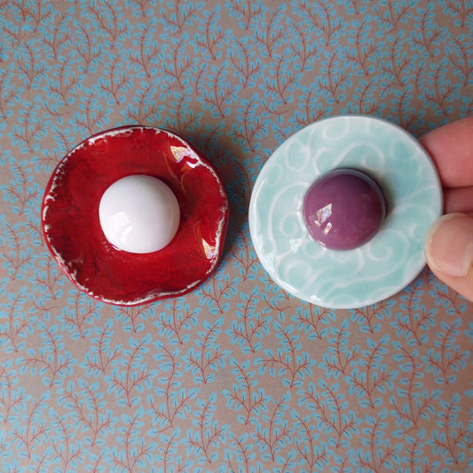 Spilla Bon Bon in ceramica rossa e bianca, con base in metallo.