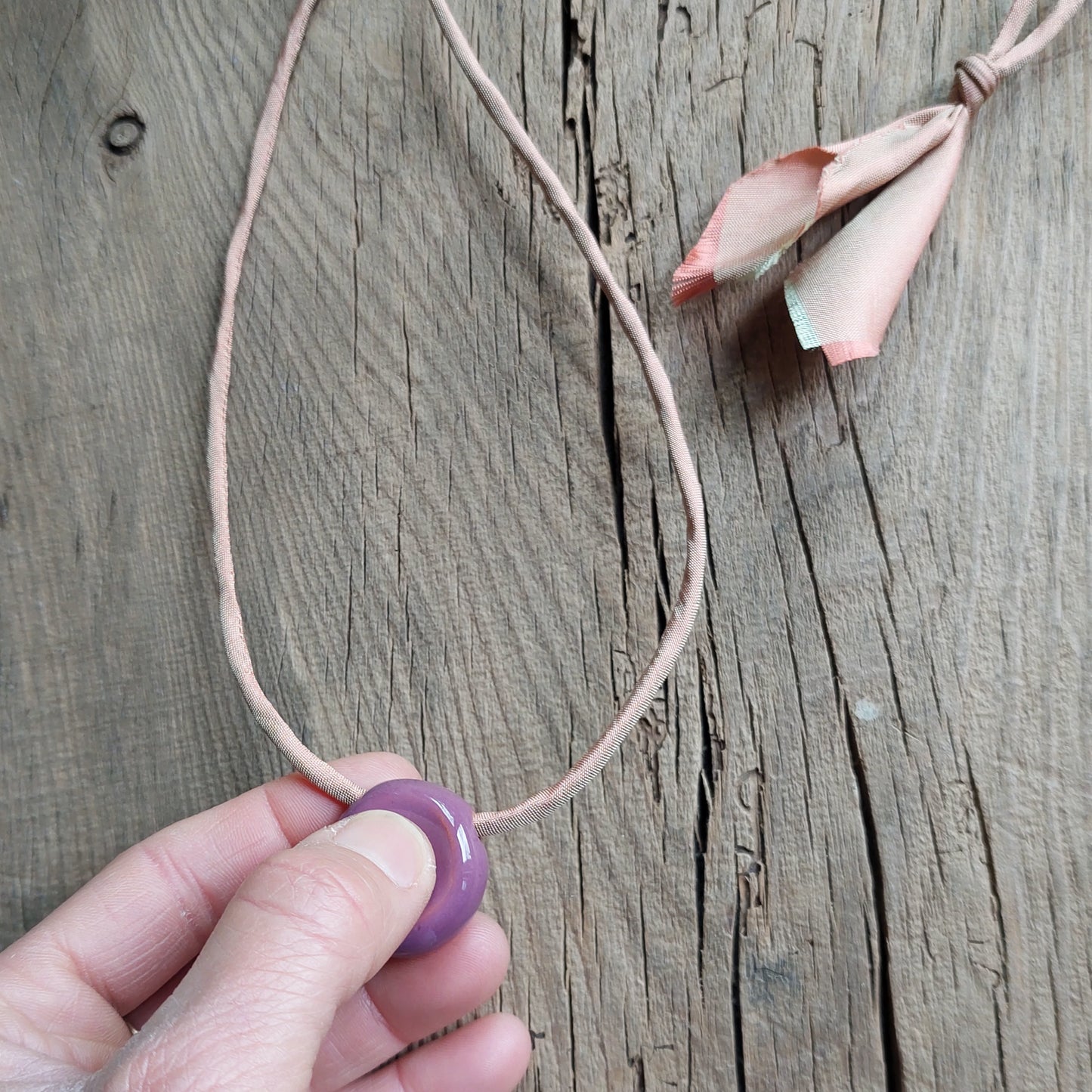 Collana donna con perla worry stones in ceramica viola e laccio in seta rosa.